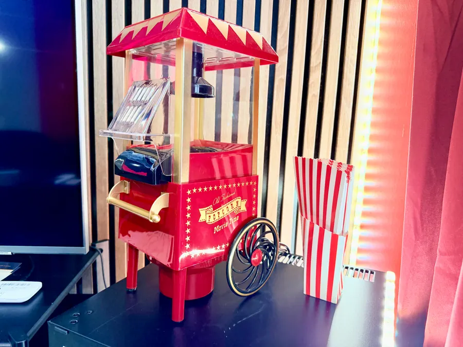 La machine à popcorn et ses cornets rayés, posée à côté de l’écran