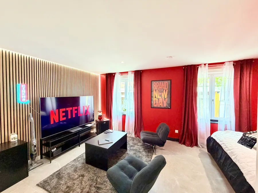 Le salon face à l'écran de 77 pouces, mur de tasseaux rétroéclairé et enseigne cinéma